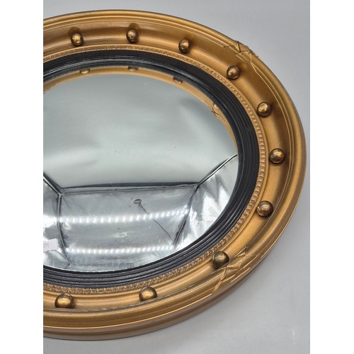 245 - Regency style gilt framed convex mirror, fitted with ball design. [48cm diameter]