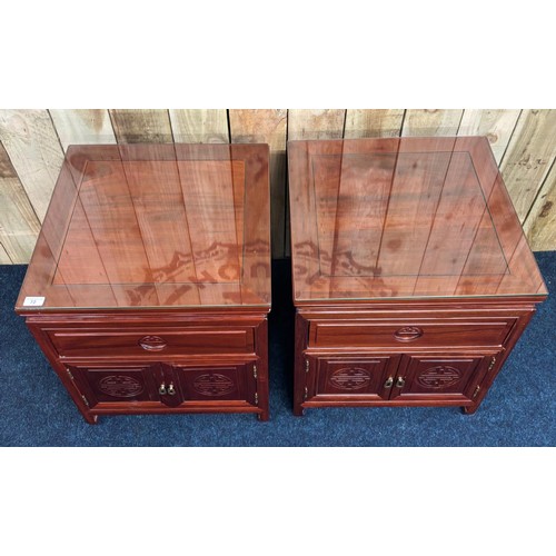 206 - A Pair of Chinese rosewood bedside cabinets. Fitted with glass top protectors. [56x51x51cm]