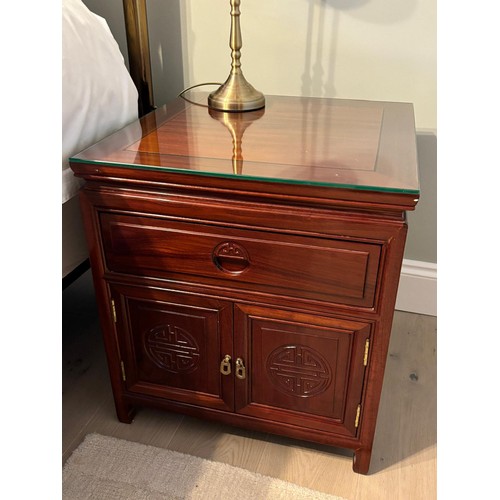 206 - A Pair of Chinese rosewood bedside cabinets. Fitted with glass top protectors. [56x51x51cm]