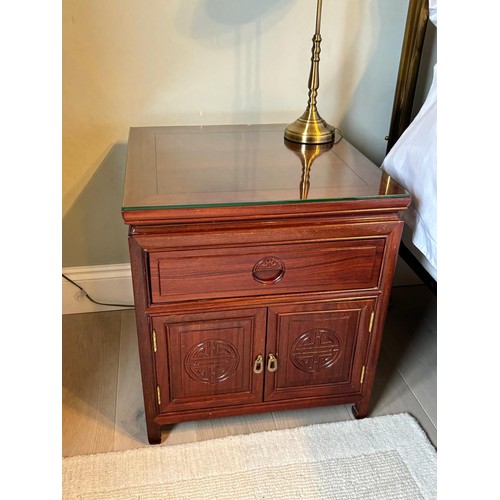 206 - A Pair of Chinese rosewood bedside cabinets. Fitted with glass top protectors. [56x51x51cm]