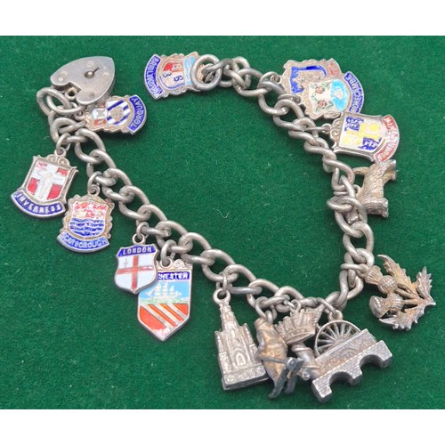 82 - Silver charm bracelet fitted with silver and enamel souvenir shield charms. Together with A dirk sha... 