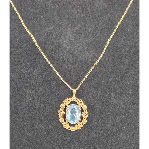 84 - 9ct yellow gold ornate pendant fitted with a blue aquamarine gem stone and a 9ct yellow gold chain. ... 