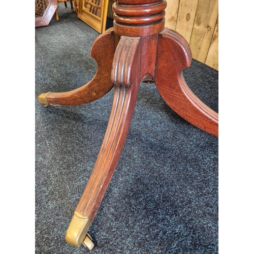 516 - Georgian period flip top parlour table. Fitted with a brass edged trim. [73cm high. 116cm diameter]