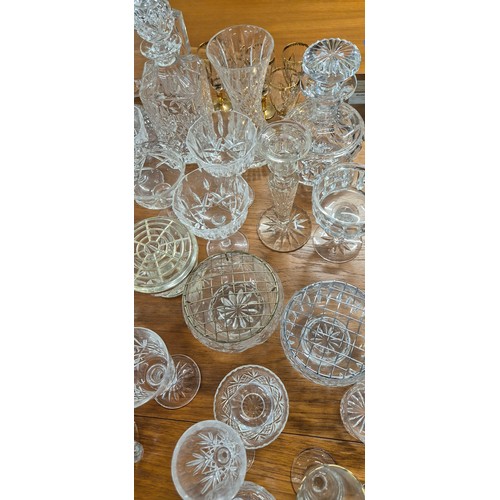 552 - A Large collection of crystal and glass ware; Decanters, candlesticks, vases and drinking glasses