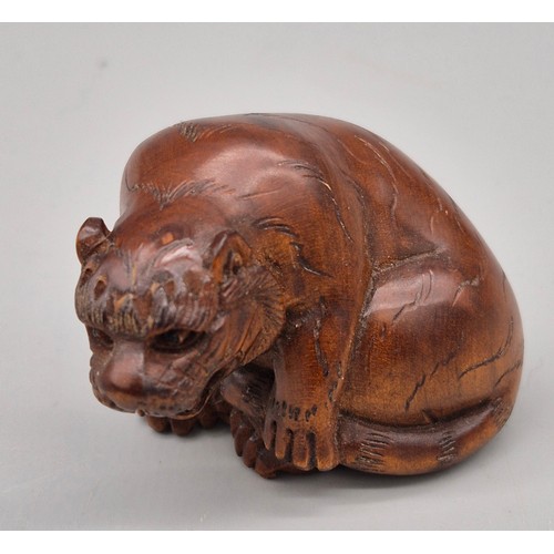 16 - Japanese hand carved boxwood netsuke in the form of a seated tiger. Signed and fitted with black bea... 