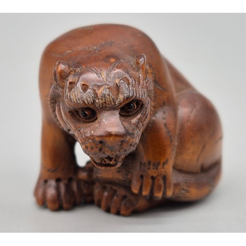 16 - Japanese hand carved boxwood netsuke in the form of a seated tiger. Signed and fitted with black bea... 