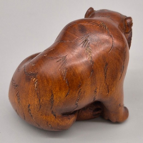 16 - Japanese hand carved boxwood netsuke in the form of a seated tiger. Signed and fitted with black bea... 