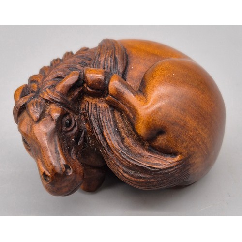 46 - Japanese hand carved boxwood netsuke in the form of a horse laying down. Signed. [4cm length]