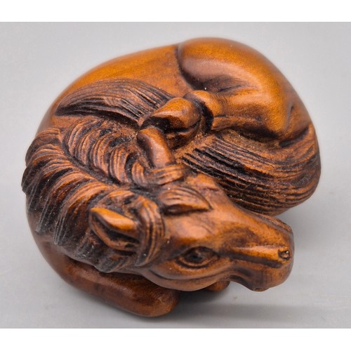 46 - Japanese hand carved boxwood netsuke in the form of a horse laying down. Signed. [4cm length]