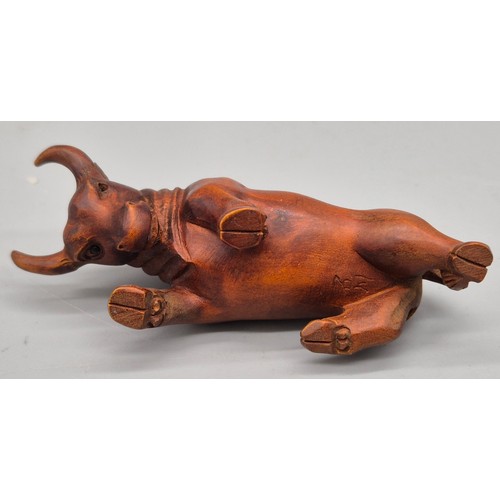 26 - Japanese hand carved boxwood netsuke in the form of a Bull. Signed. [7cm length]