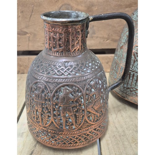 389 - Two antique Persian copper pourers/ jugs. Both worked with raised relief figures and panels. [Talles... 