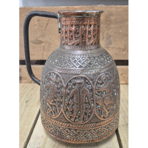 389 - Two antique Persian copper pourers/ jugs. Both worked with raised relief figures and panels. [Talles... 