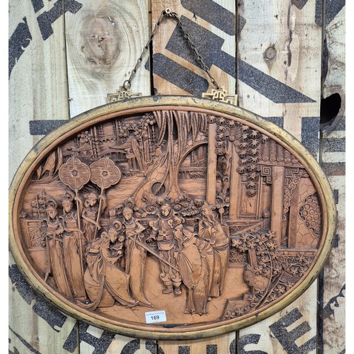 169 - Antique Chinese hand carved wall panel. Oval form and depicting group scene. Finished with a gilt fr... 