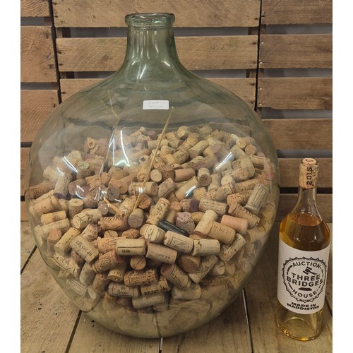 410A - Large vintage Demijohn Carboy containing a quantity of wine corks.