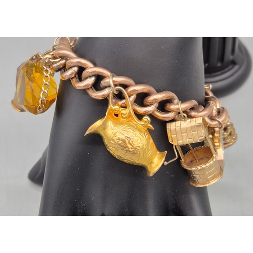 50A - Heavy antique 9ct rose gold charm bracelet fitted with various 9ct yellow gold charms. Includes one ... 