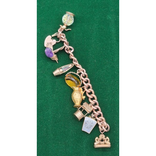 50A - Heavy antique 9ct rose gold charm bracelet fitted with various 9ct yellow gold charms. Includes one ... 