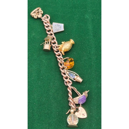 50A - Heavy antique 9ct rose gold charm bracelet fitted with various 9ct yellow gold charms. Includes one ... 