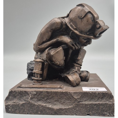 202 - Bronzed Cold cast figure of a miner sat beside a lamp by Robert Olley. Raised on a rocky plinth base... 