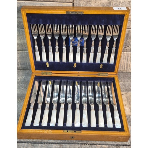 73 - Antique oak cased fork and knife set, fitted with mother of pearl handles. Harrisons Bros & Houson S... 