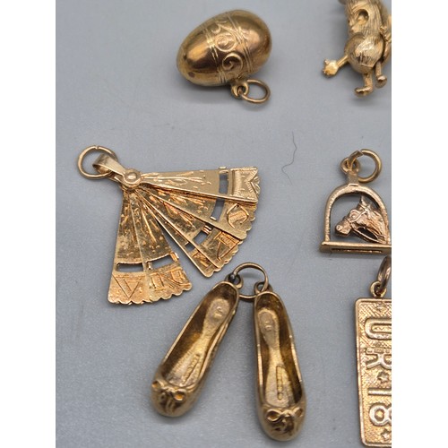 64 - 10 various 9ct yellow gold charms; Ballet shoes, spider web, Jelley bean, fan and various others. [1... 