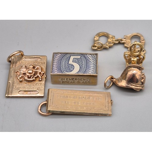 59 - Six various 9ct yellow gold charms; In Emergency Break Glass- contains bank note, British passport, ... 