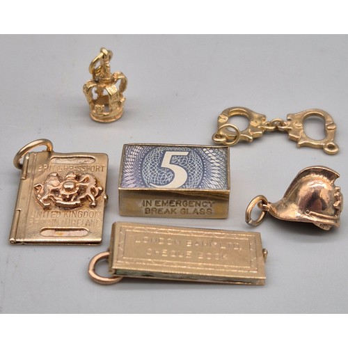 59 - Six various 9ct yellow gold charms; In Emergency Break Glass- contains bank note, British passport, ... 