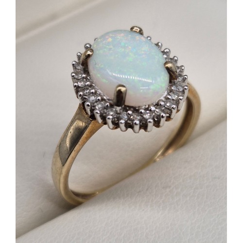 17 - 9ct yellow gold, opal and diamond stone ring. Large cabochon opal gem stone surrounded by round cut ... 