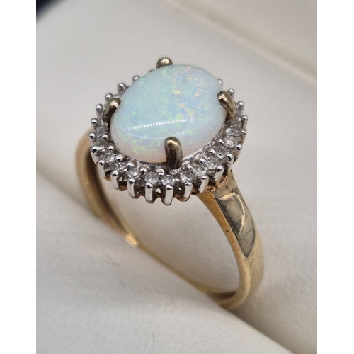 17 - 9ct yellow gold, opal and diamond stone ring. Large cabochon opal gem stone surrounded by round cut ... 