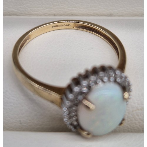 17 - 9ct yellow gold, opal and diamond stone ring. Large cabochon opal gem stone surrounded by round cut ... 