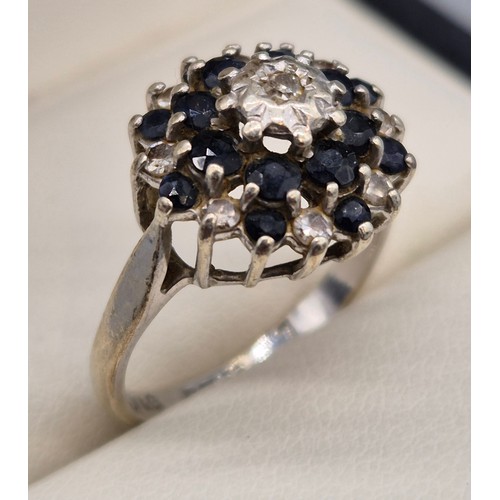20 - 9ct white gold, sapphire and diamond cluster ring. 3.91Grams. Ring size O.