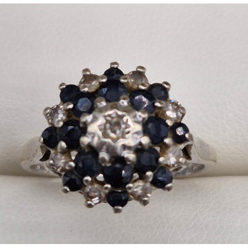 20 - 9ct white gold, sapphire and diamond cluster ring. 3.91Grams. Ring size O.