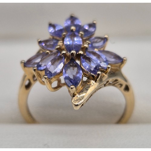 23 - 9ct yellow gold and blue/ purple tourmaline gem stone ring in the shape of a flower. 3.13grams. Ring... 