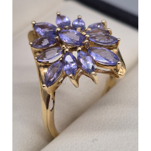 23 - 9ct yellow gold and blue/ purple tourmaline gem stone ring in the shape of a flower. 3.13grams. Ring... 