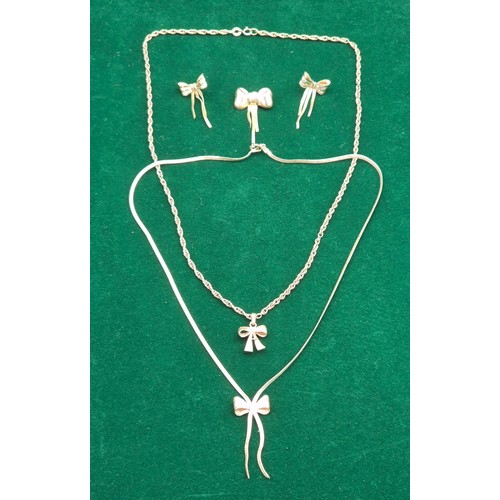 39 - A Lot of 9ct yellow gold jewellery design with ribbon design. Brooch, earrings, chains and pendants.... 