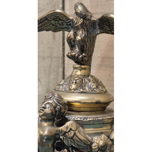 284 - Antique heavy brass ink well pot; Lid designed with an eagle finial. Body detailed with three cherub... 