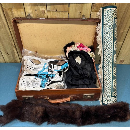 388 - Case containing vintage clothing; Victorian Mourning bonnet, fur stoles, black skirt and small rug.