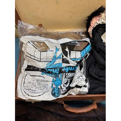 388 - Case containing vintage clothing; Victorian Mourning bonnet, fur stoles, black skirt and small rug.