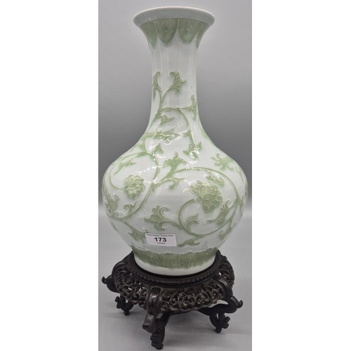 173 - Antique Chinese raised relief dragon pattern vase with reign mark to base on a wood carved stand.