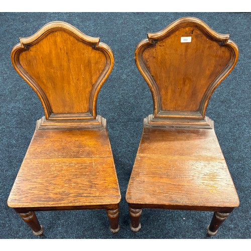 354 - John Taylor of Edinburgh
Two Victorian hall chairs with shield back and raised on turned legs. 91cm ... 