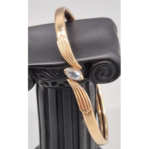 51 - 9ct yellow gold bangle fitted with a blue quartz gem stone. 9.86grams.