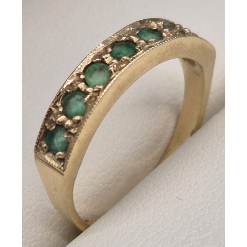 28 - 14ct yellow gold and green stone ring. Fitted with seven round cut green gem stones. 3.05grams. Ring... 