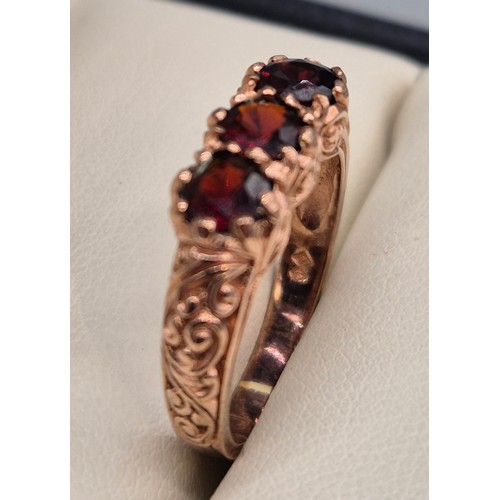 42 - 9ct rose gold and garnet gem stone ring. Three round cut garnets. 3.43grams. Ring size M.