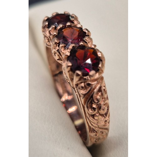 42 - 9ct rose gold and garnet gem stone ring. Three round cut garnets. 3.43grams. Ring size M.