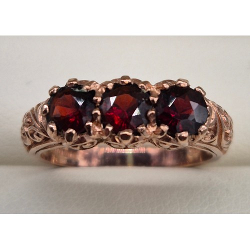 42 - 9ct rose gold and garnet gem stone ring. Three round cut garnets. 3.43grams. Ring size M.