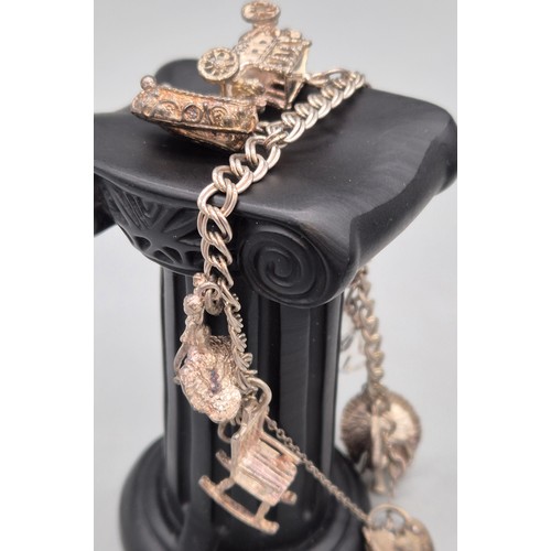 29 - Silver charm bracelet and charms. Together with silver chain and pendant.