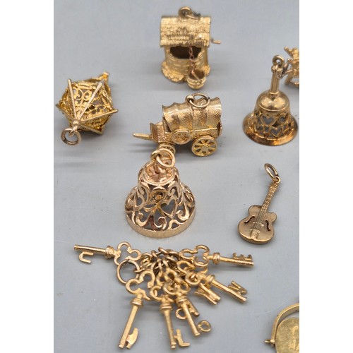 55 - A Collection of 9ct and 14ct yellow gold charms. One 14ct gold bell charm. The rest are 9ct gold- we... 