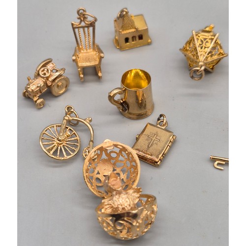55 - A Collection of 9ct and 14ct yellow gold charms. One 14ct gold bell charm. The rest are 9ct gold- we... 