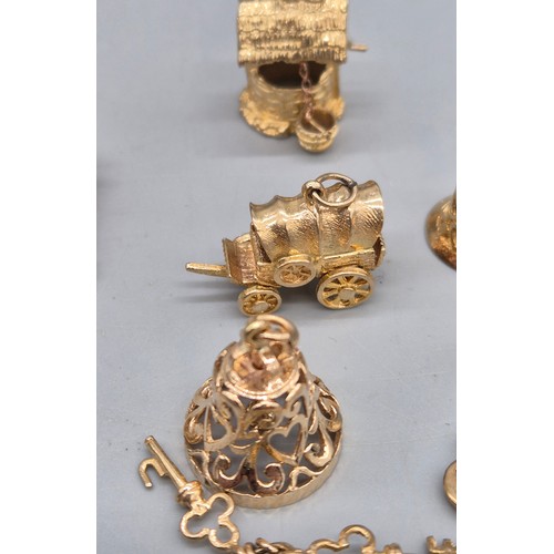 55 - A Collection of 9ct and 14ct yellow gold charms. One 14ct gold bell charm. The rest are 9ct gold- we... 