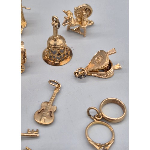 55 - A Collection of 9ct and 14ct yellow gold charms. One 14ct gold bell charm. The rest are 9ct gold- we... 