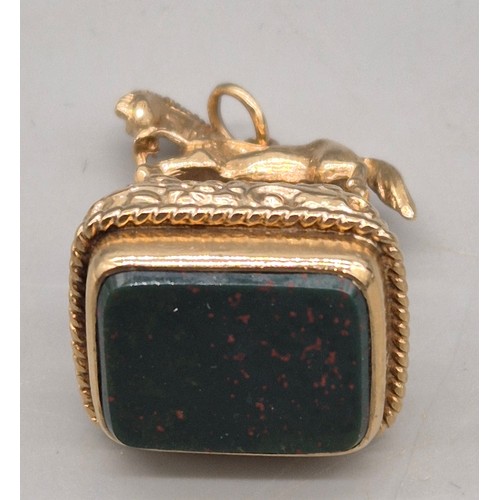 74 - 9ct yellow gold ornate horse figural fob seal. Blood stone. 15.47grams.